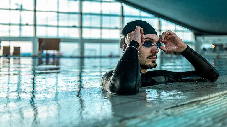 Man with goggles swimming in pool