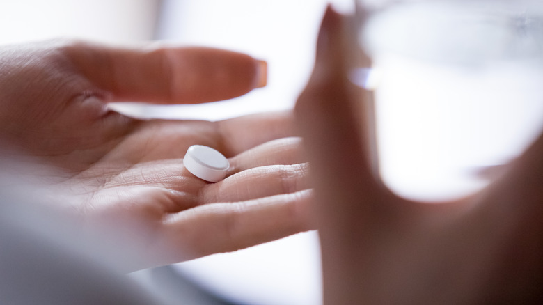 Woman taking pill with water