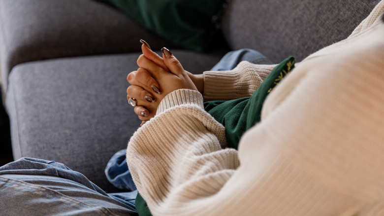 A woman's hands clasped in worry