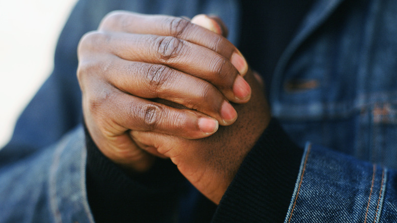 A man's hands cracking knuckles