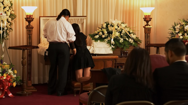 funeral guests visiting open casket