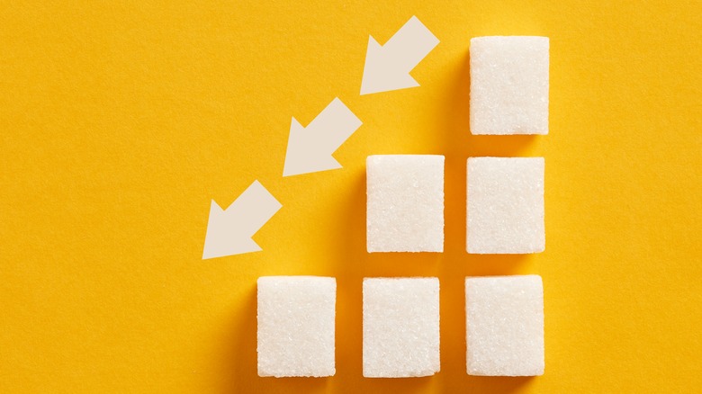 sugar cubes in a step formation with a downward pointing arrow 