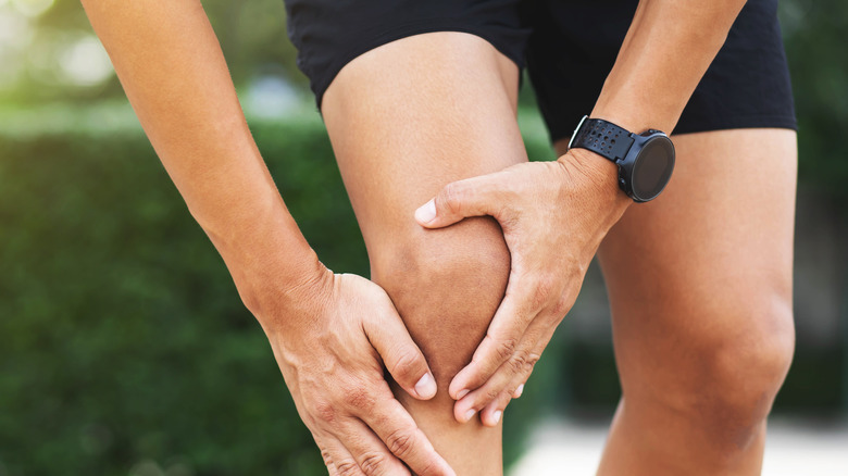 man holding his knee in pain indicating joint inflammation or arthritis