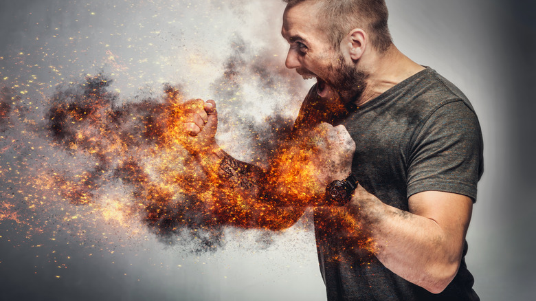 a man looking happy and excited pumping his fists with sparks of fire