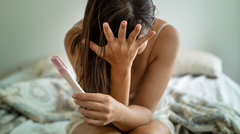 distraught woman holding negative pregnancy test 