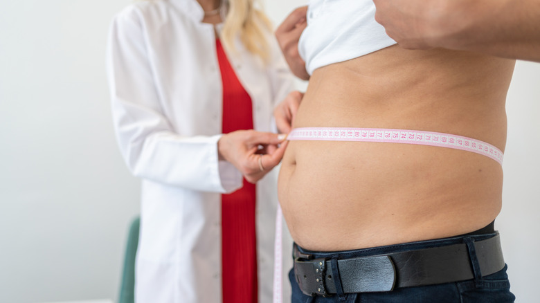 Doctor measuring patient's waist