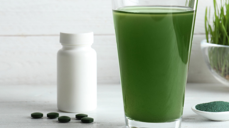 green juice and pills on white
