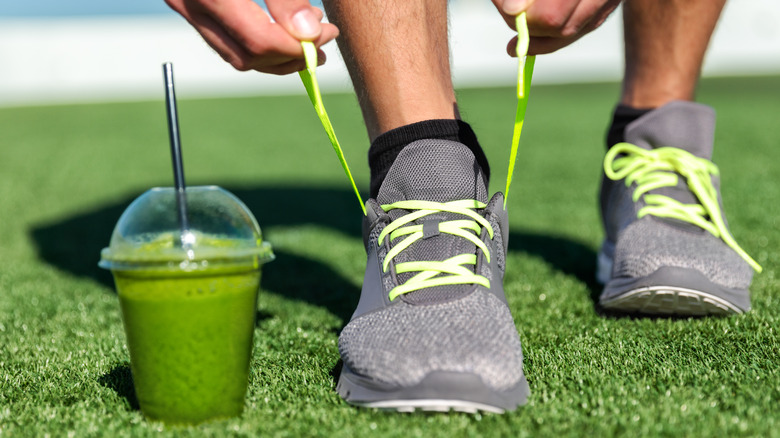 man about to tie shoes with green juice 