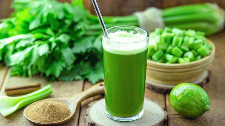 green juice on table with celery and lime 