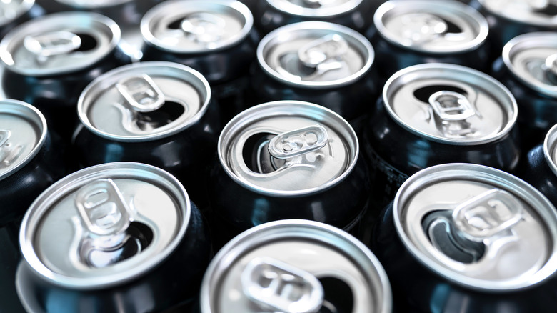 close up of multiple opened soda cans