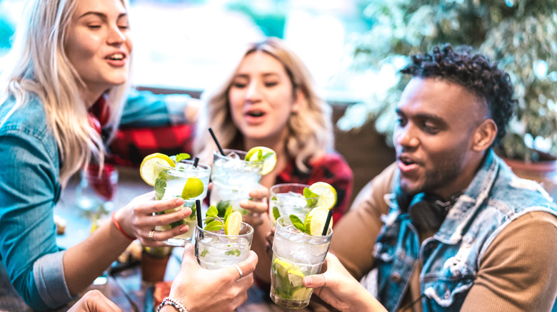 group of friends toasting with cocktails