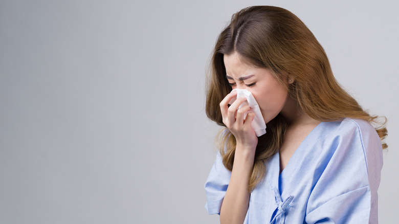 woman with cold blowing nose