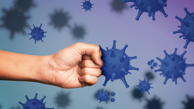 a fist fighting a bacteria symbolizing strong immunity 