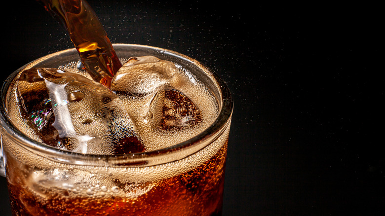 pouring a glass of soda with ice