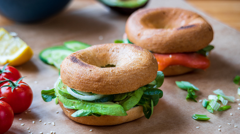 Two bagel sandwiches with greens on top