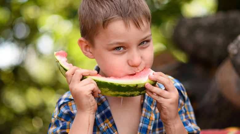 A child munches on watermelon