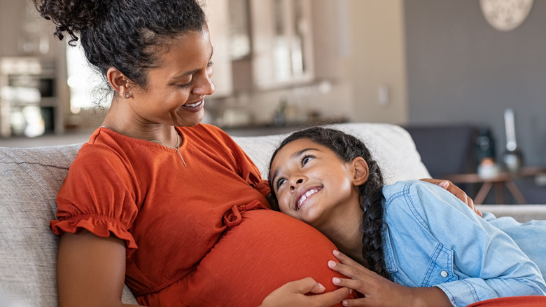 pregnant woman smiling with young girl