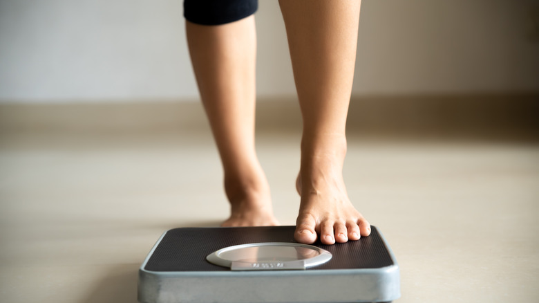 woman stepping on scale