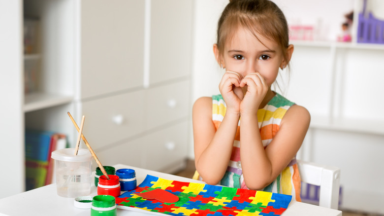 young girl painting jigsaw puzzle