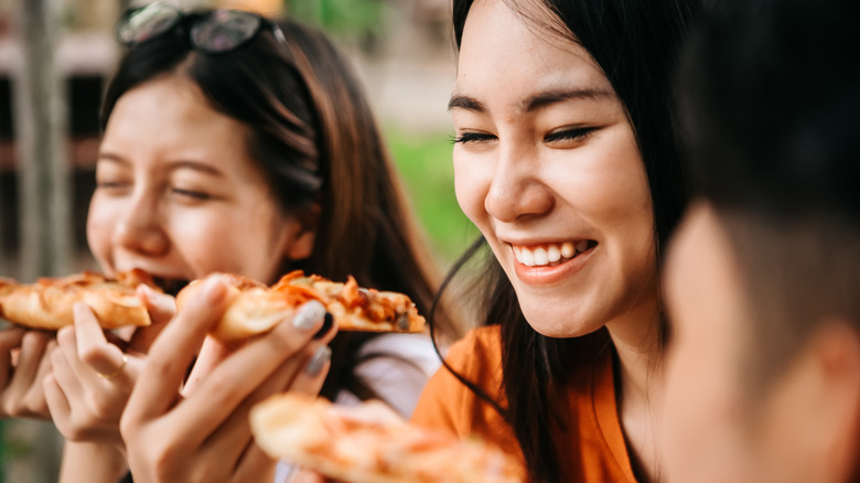 women eating pizza