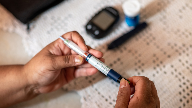 person preparing insulin shot