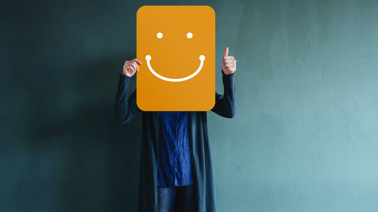 person holding smiley face sign