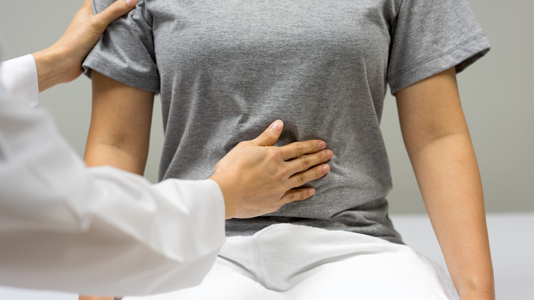 doctor examining woman's stomach