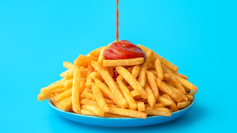 ketchup being poured on french fries