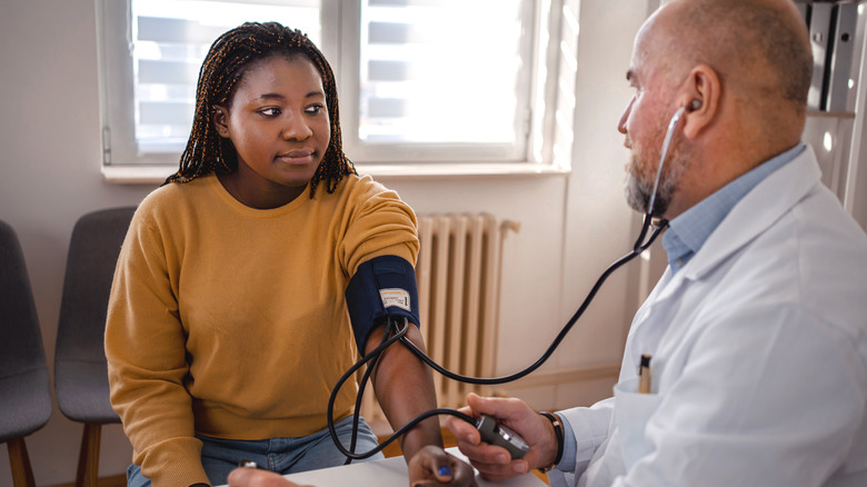 Doctor checking a woman's blood pressure