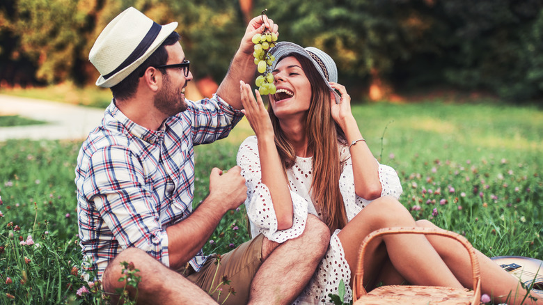 A couple eats grapes together