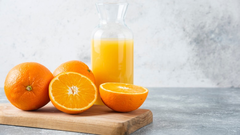 whole oranges and orange juice on table