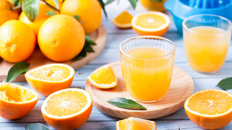 oranges and glasses of orange juice on table