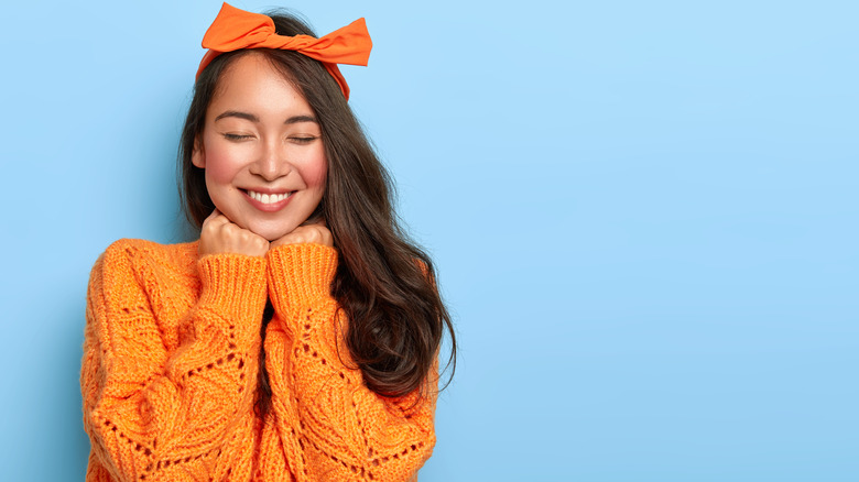 woman wearing orange sweater and headband