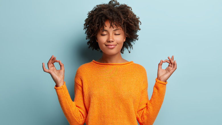 woman wearing orange sweater meditating