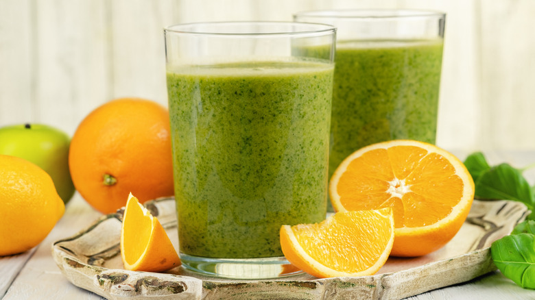 oranges and glasses of green juice