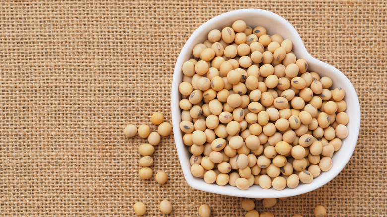 soybeans in heart shaped bowl on burlap background