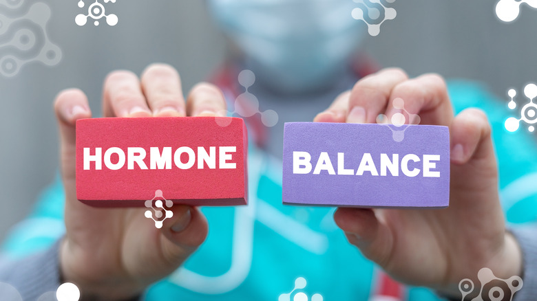 medical professional holding signs that say hormone balance