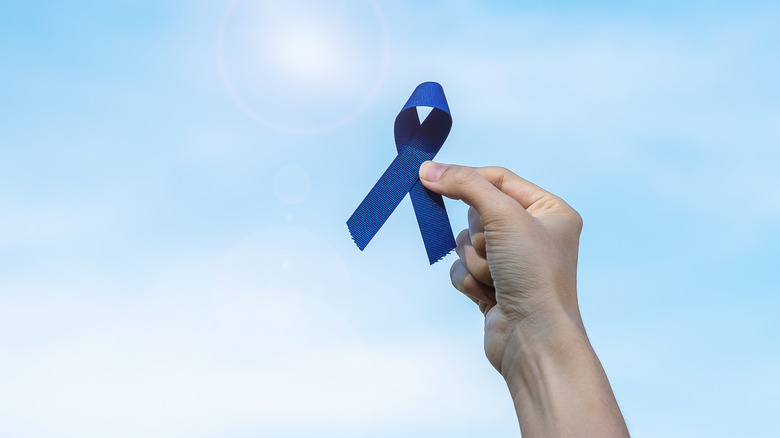 person holding colorectal cancer ribbon