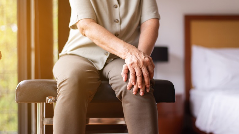 older woman holding knee