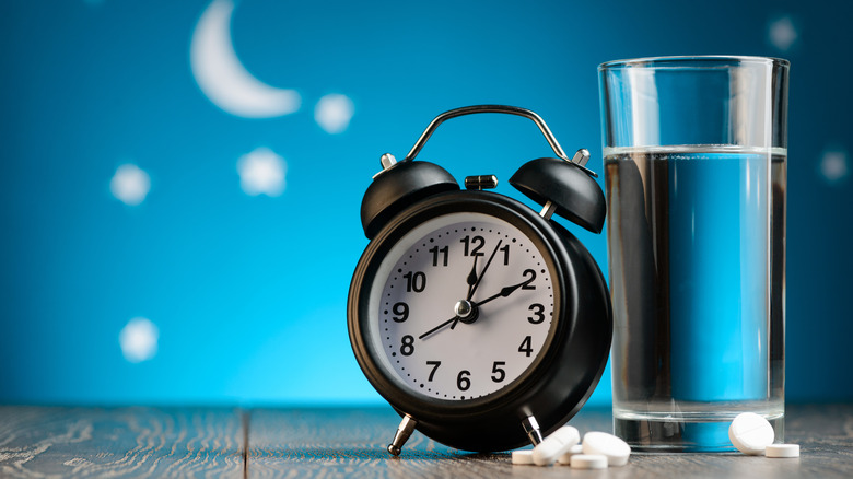 Clock and glass of water at night