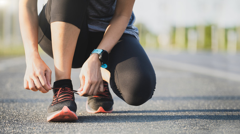 Runner kneeling down, tying their shoelace