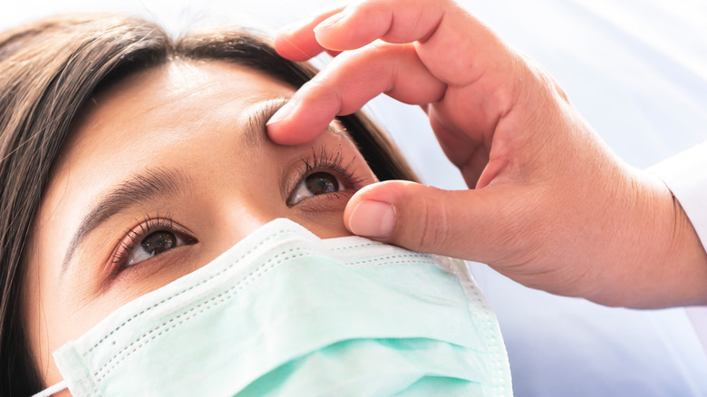 masked woman getting eyes checked