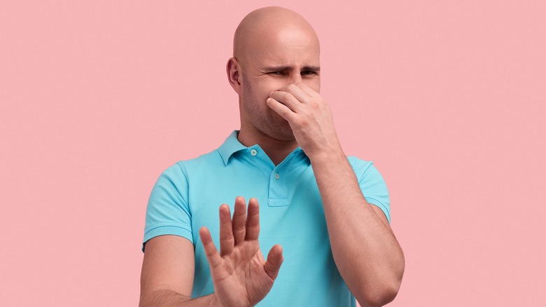 bald man pinching nose 