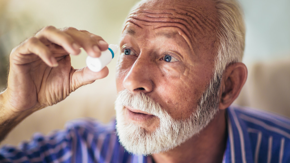 man using eye drops for glaucoma