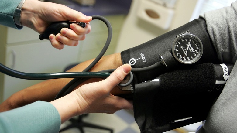 A person checking another person's blood pressure