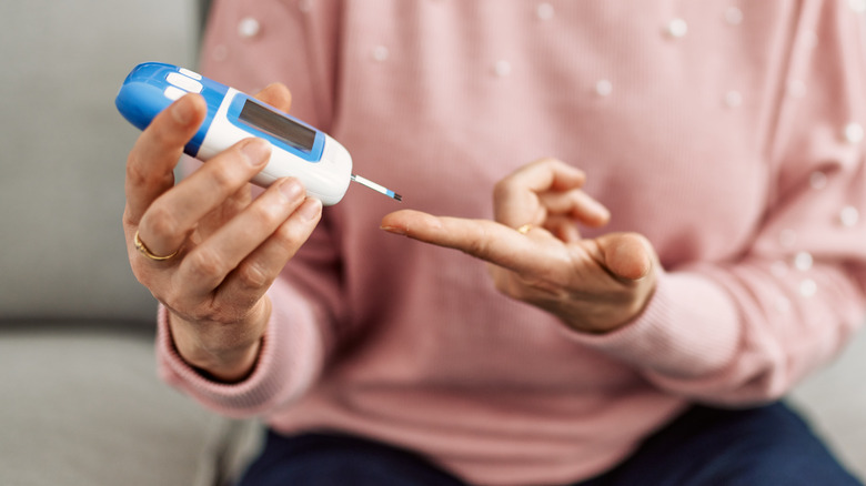 A person using a glucometer to test their blood sugar