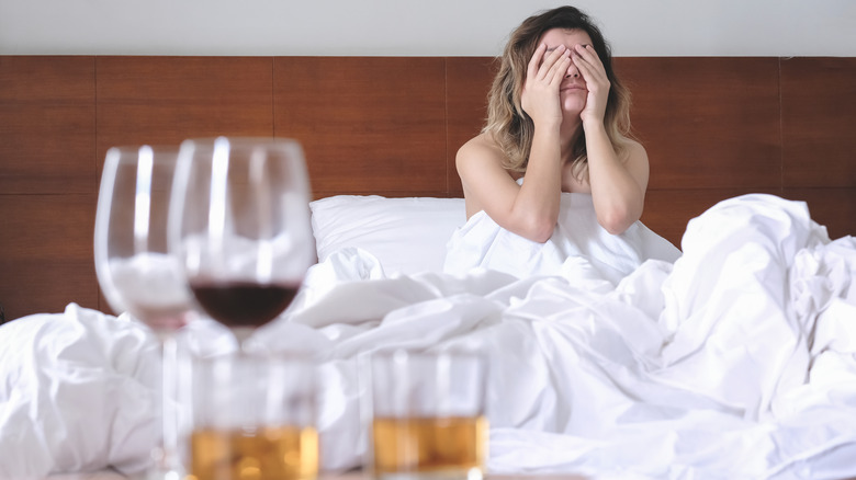 woman bed hungover anxious