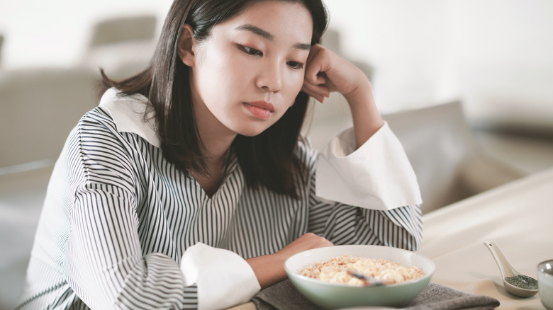 woman looking depressed in front of food