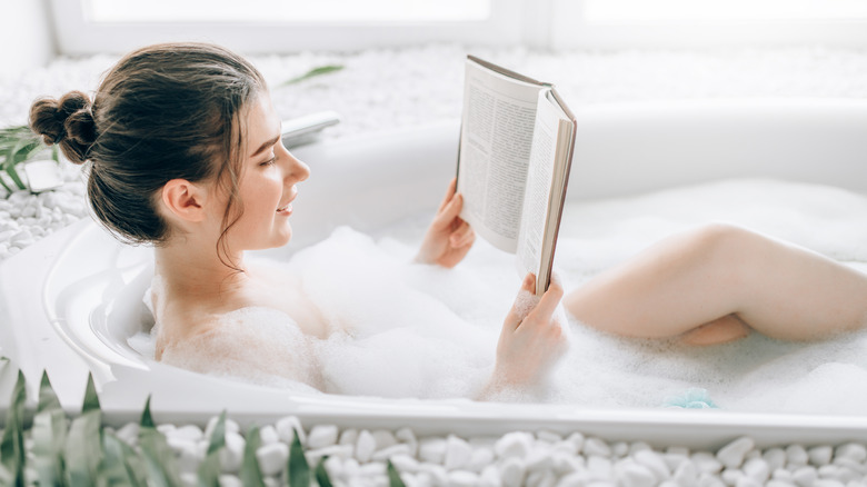woman reading taking bubble bath 