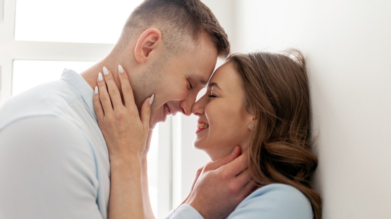 A man and a woman embracing just before a kiss